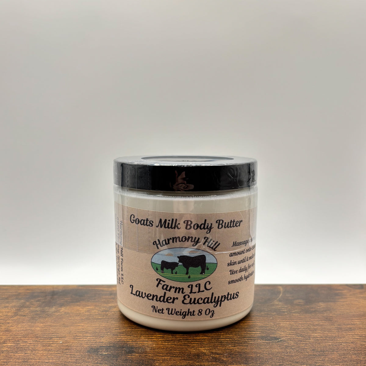 Jar of lavender eucalyptus goats milk body butter on a wooden surface with a white background