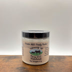 Jar of patchouli goats milk body butter on a wooden surface with a white background