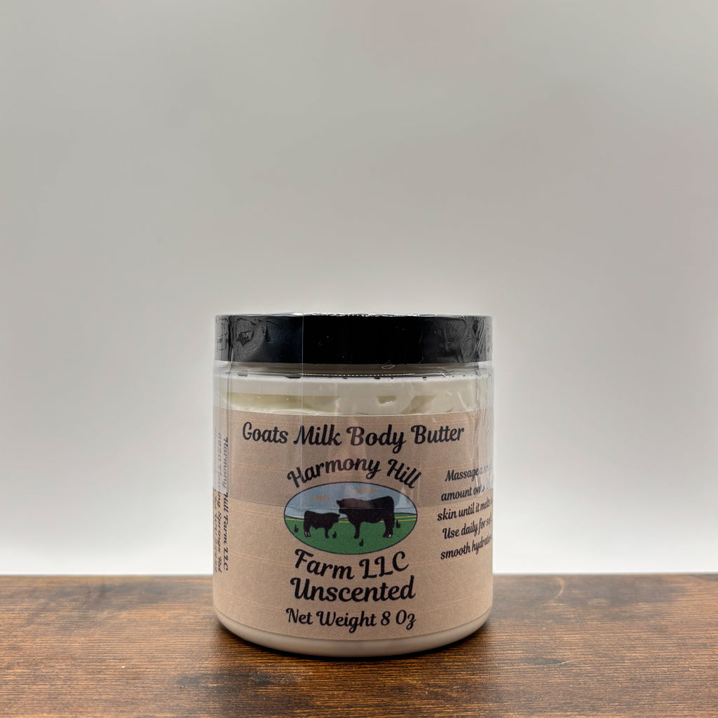Jar of unscented goats milk body butter on a wooden surface with a white  background