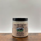 Jar of unscented goats milk body butter on a wooden surface with a white  background