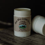 White lotion stick with a brown label on a wooden surface