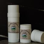 Two containers of Bee Wax Lotion Stick from Harmon Hill Farm LLC on a dark background