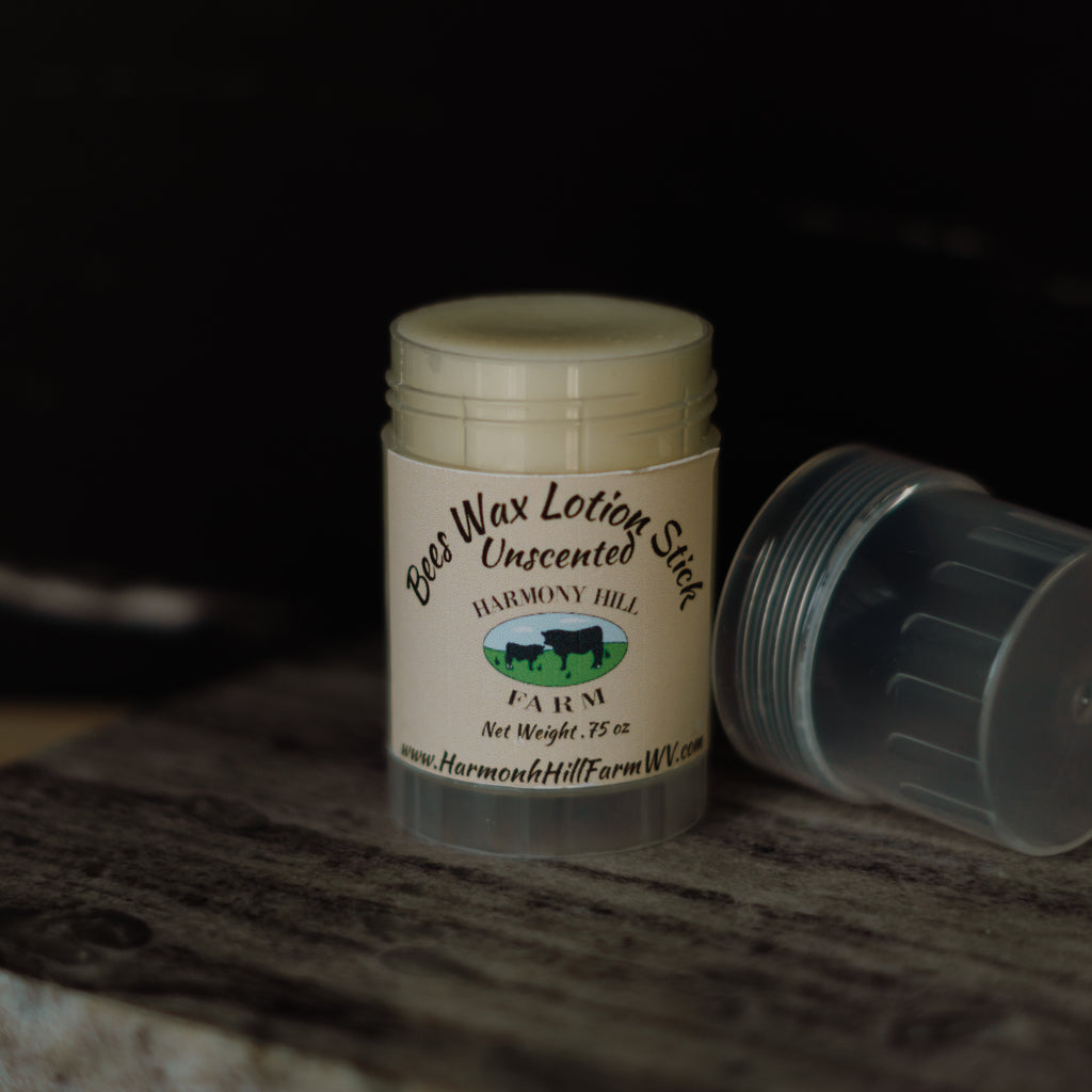 Beeswax lotion stick with visible branding on a wooden surface