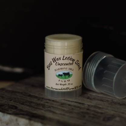 Beeswax lotion stick with visible branding on a wooden surface