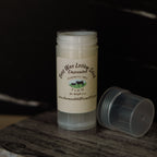 Beeswax lotion stick with a label on a dark background