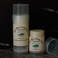Two containers of Bees Wax Lotion Stick from Harmony Hill Farm on a dark background